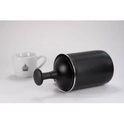 Napěňovač mléka z vrchní strany v černém provedení od značky Bialetti Tuttocrema o objemu 330ml na bílém pozadí společně s šálkem s logem Lázeňské kávy