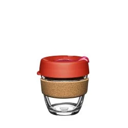 Skleněný KeepCup termohrnek o objemu 227 ml s červeným víkem a korkovým držákem na bílém pozadí