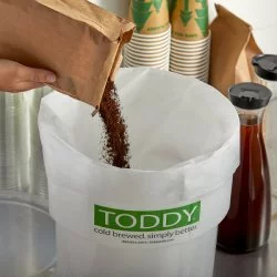 Nasypávaní kávy do papírového filtru do plastové nádoby od Toddy Commercial pro přípravu Cold Brew 