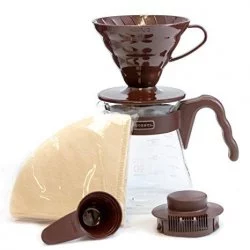 Sada pro přípravu kávy ve V60 značky Hario v hnědé barvě s papírovými filtry hnědou lžící na kávu hnědým driprem a poklop pro skleněnou konvičku