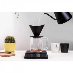 Váha Felicita Parallel Plus při zalévání filtrované kávy s konvicí a kaktusem.