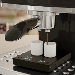 Baristická digitální váha Black Mirror při přípravě espressa se dvěmi bílými šálky a portafilterem
