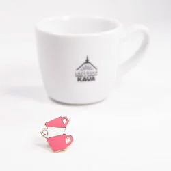 Edo odznak růžové šálky vedle šálku na kávu.