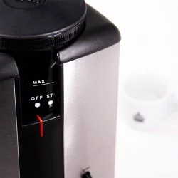 Ovládáví hrubosti mletí u elektrického mlýnku na kávu s bílým hrnkem značky Lázeňská káva