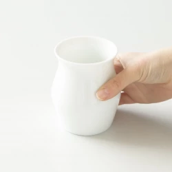 Bílý Sensory Cup v ruce.