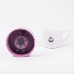 Detail víka růžové termolahve zevnitř s bílým pozadím a šálkem lázeňské kávy