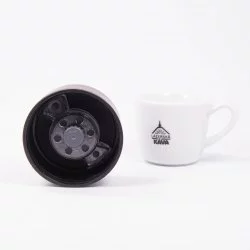 Detail na víčko termohrnku ze spodní strany s lázeňskou kávou v pozadí.