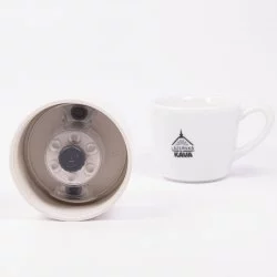 Detail na víčko termosky ze spodní strany s lázeňskou kávou v pozadí.
