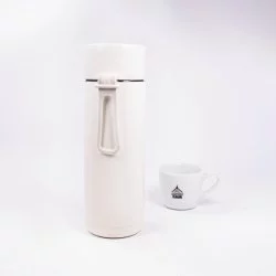 Keramická termoska ze zadní strany s lázeňskou kávou v pozadí