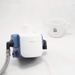 Připojovací sada pro filtrování vody značky BMWT Beasthead FLEX a v pozadí šálek s motivy Lázeňské kávy