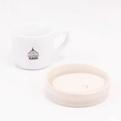 Ekologické béžové víčko Huskee na bílém pozadí s šálkem lázeňské kávy