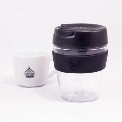 Plastový termohrnek KeepCup Kit s černým víkem na bílém pozadí s šálkem lázeňské kávy