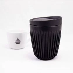Černý ekologický termohrnek s víčkem o objemu 240 ml na bílém pozadí s šálkem lázeňské kávy