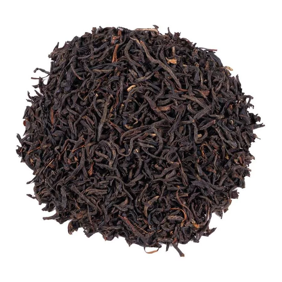 Vysypaný černý čaj Assam na bílém pozadí, pohled shora