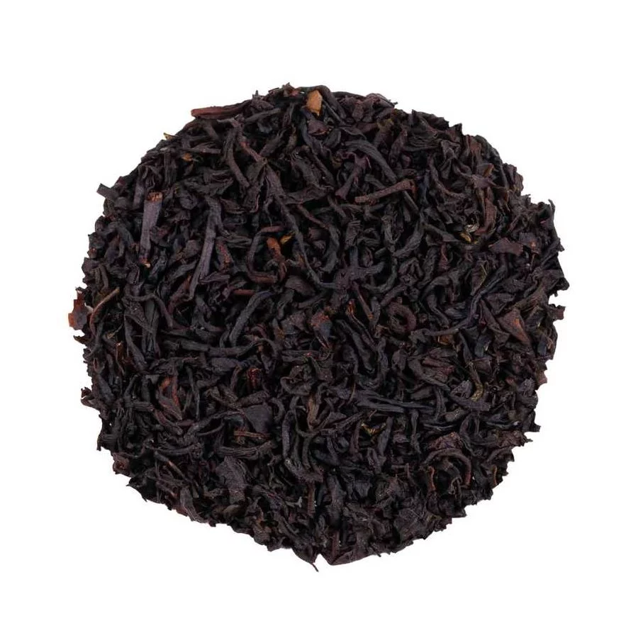 Vysypaný černý čaj Earl Grey na bílém pozadí, pohled shora