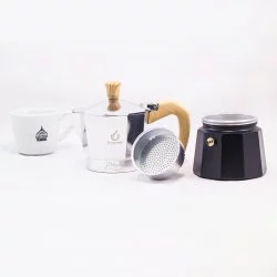 Pohled na rozloženou moka konvičku s dřevěnou rukojetí pro 3 porce kávy doplněno šálkem Lázeňské kávy