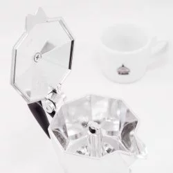 Stříbrná Bialetti Moka Express konvice, pohled do vnitřní části konvice, v pozadí šálek lázeňské kávy