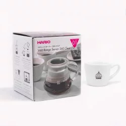 Originální papírová krabice s barevným potiskem pro Hario V60 Range Server a v pozadí bílý šálek s logem Lázeňské kávy
