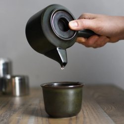 Černá porcelánová konvička na čaj Kinto LT Kyusu při nalévání.