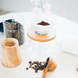 Dřevěný mlýnek Hario Coffee Mill zešikma na stole