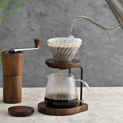 Mlýnek Hario Coffee Grinder zešikma na stole