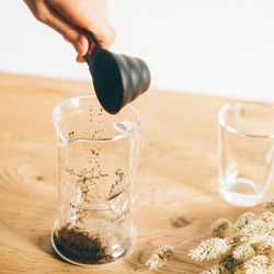 Odměrka Hario V60 vedle driperu na stole
