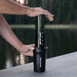 Termohrnek AeroPress vedle AeroPressu při přípravě kávy