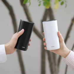 Termohrnek Hario Tumbler zešikma na stole
