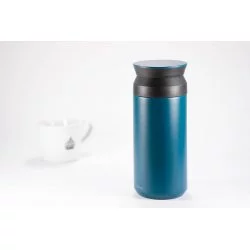 Tyrkysová nerezová termoláhev o objemu 350 ml na bílém pozadí s šálkem lázeňské kávy